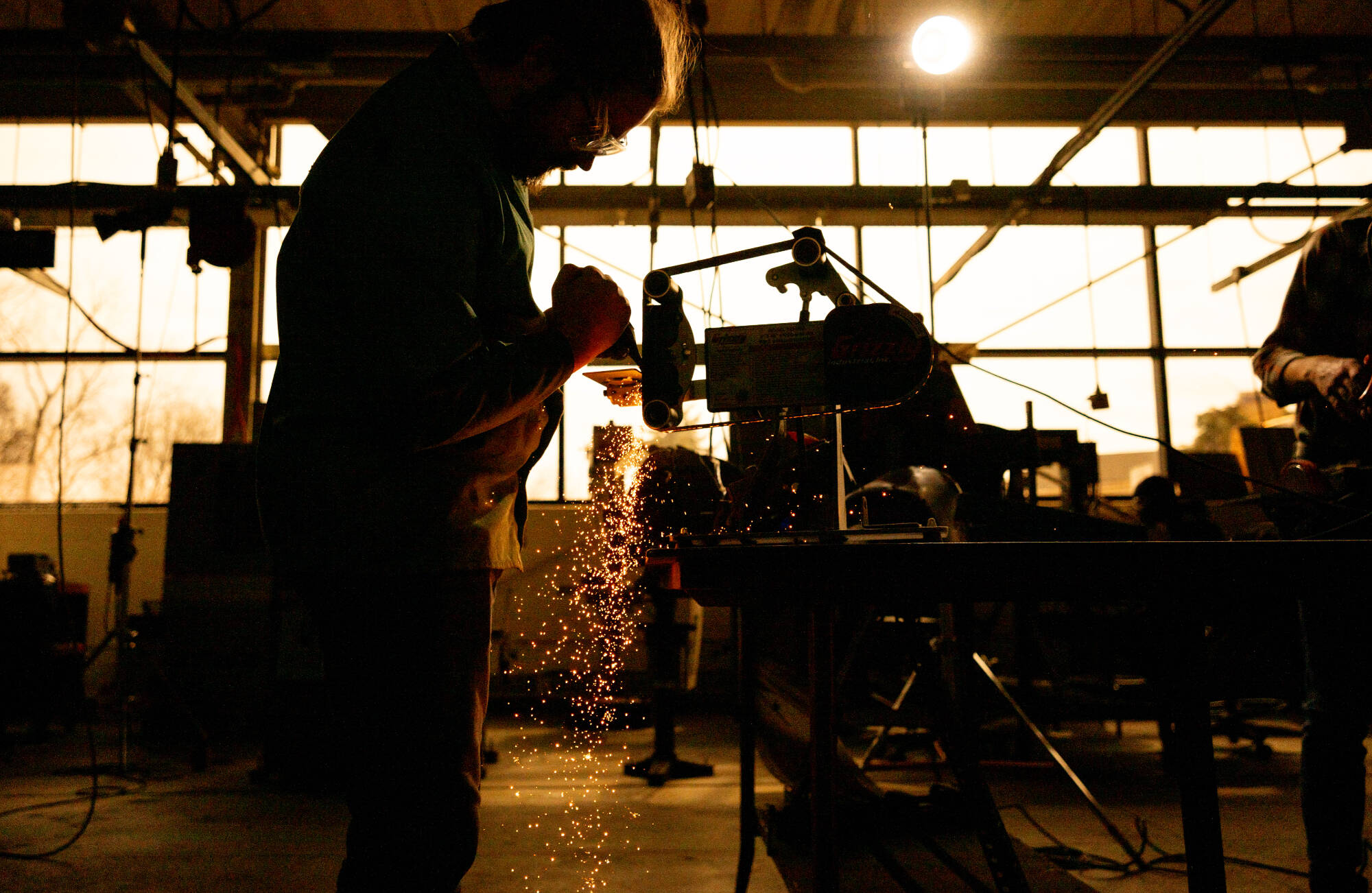 Rock Phelps, a sophomore product design and manufacturing engineering student, grinds to shape a horseman’s axe during a filming for the show “Forged with Steele” in the Keller Engineering Laboratories March 24. (Photo releases on file)